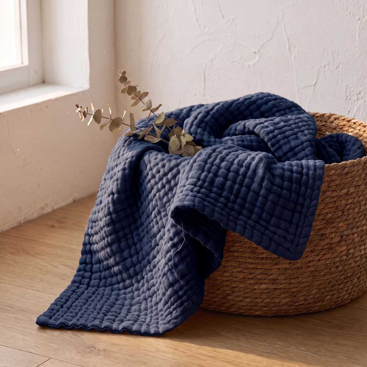 Navy gauze blanket folded in a woven basket