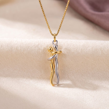 Hug Necklace in gold and silver, two figures in an embrace
