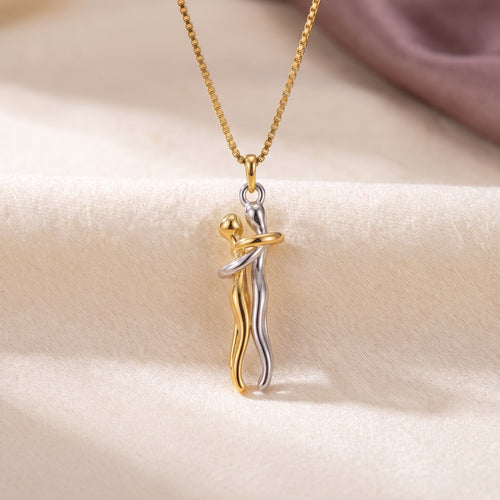 Hug Necklace in gold and silver, two figures in an embrace