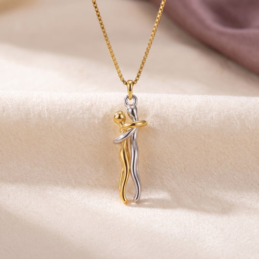 Hug Necklace in gold and silver, two figures in an embrace