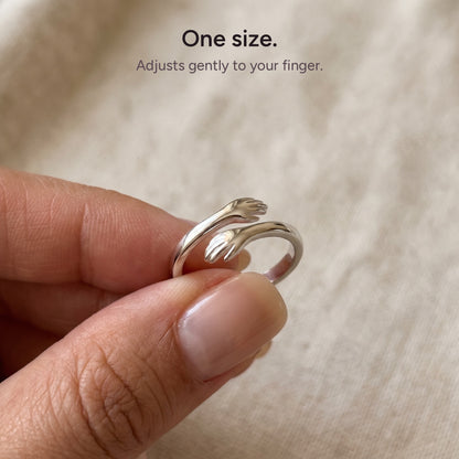 One size hug ring held between two fingers