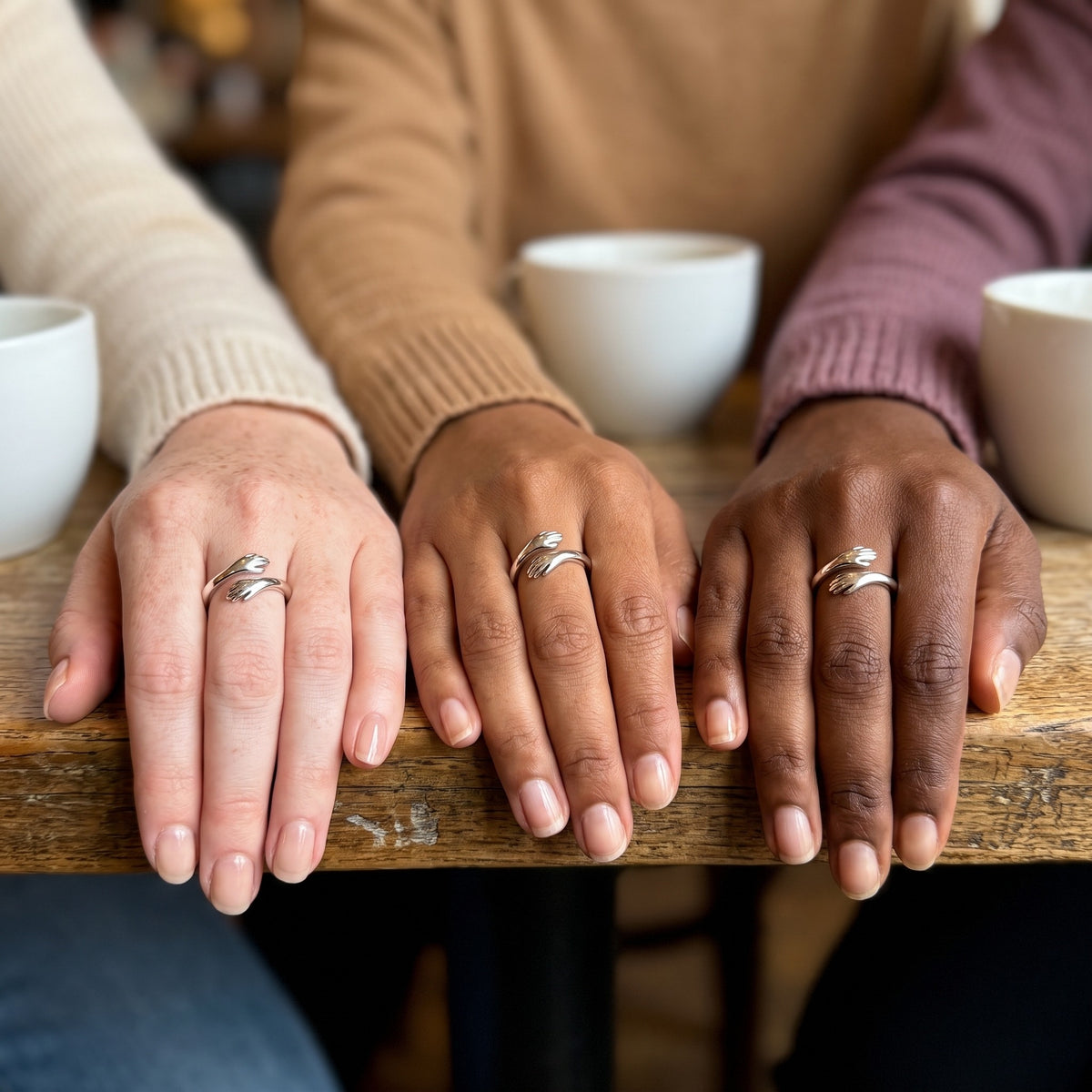 Three friends wearing the same hug ring