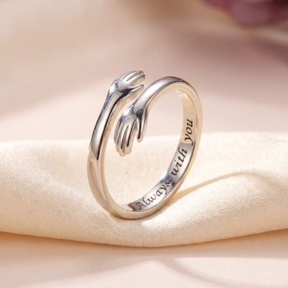 Silver hug ring with two little hands, engraved inside: Always with you
