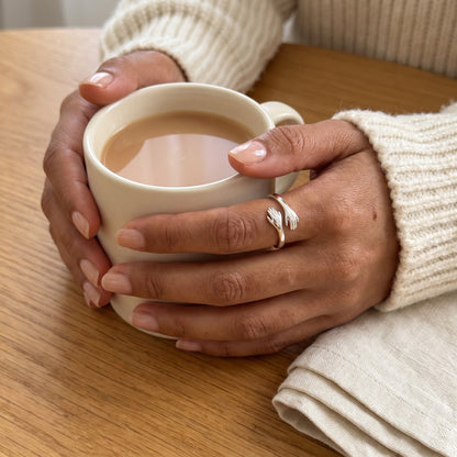 Hands around a mug of tea wearing the hug ring