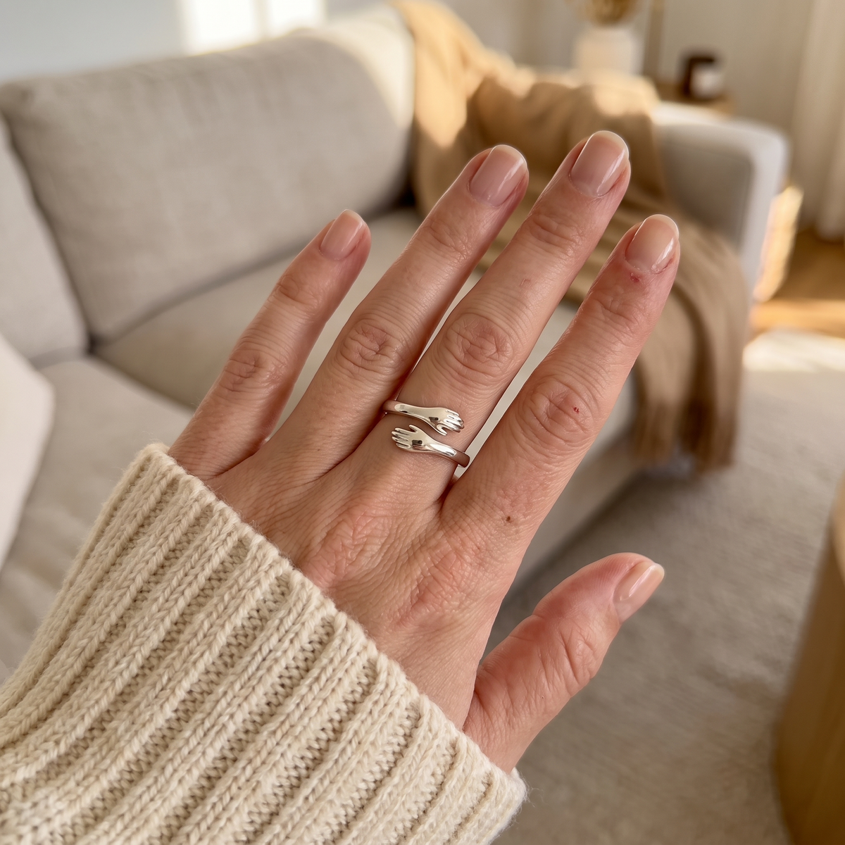 Hug ring worn with a cream jumper at home