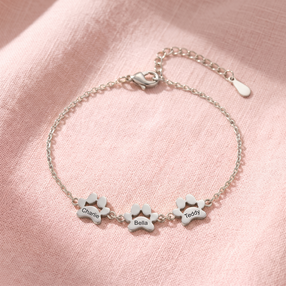 Silver paw print name bracelet with three engraved paws