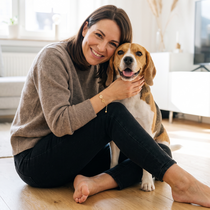 Woman hugging her beagle while wearing a gold paw name bracelet