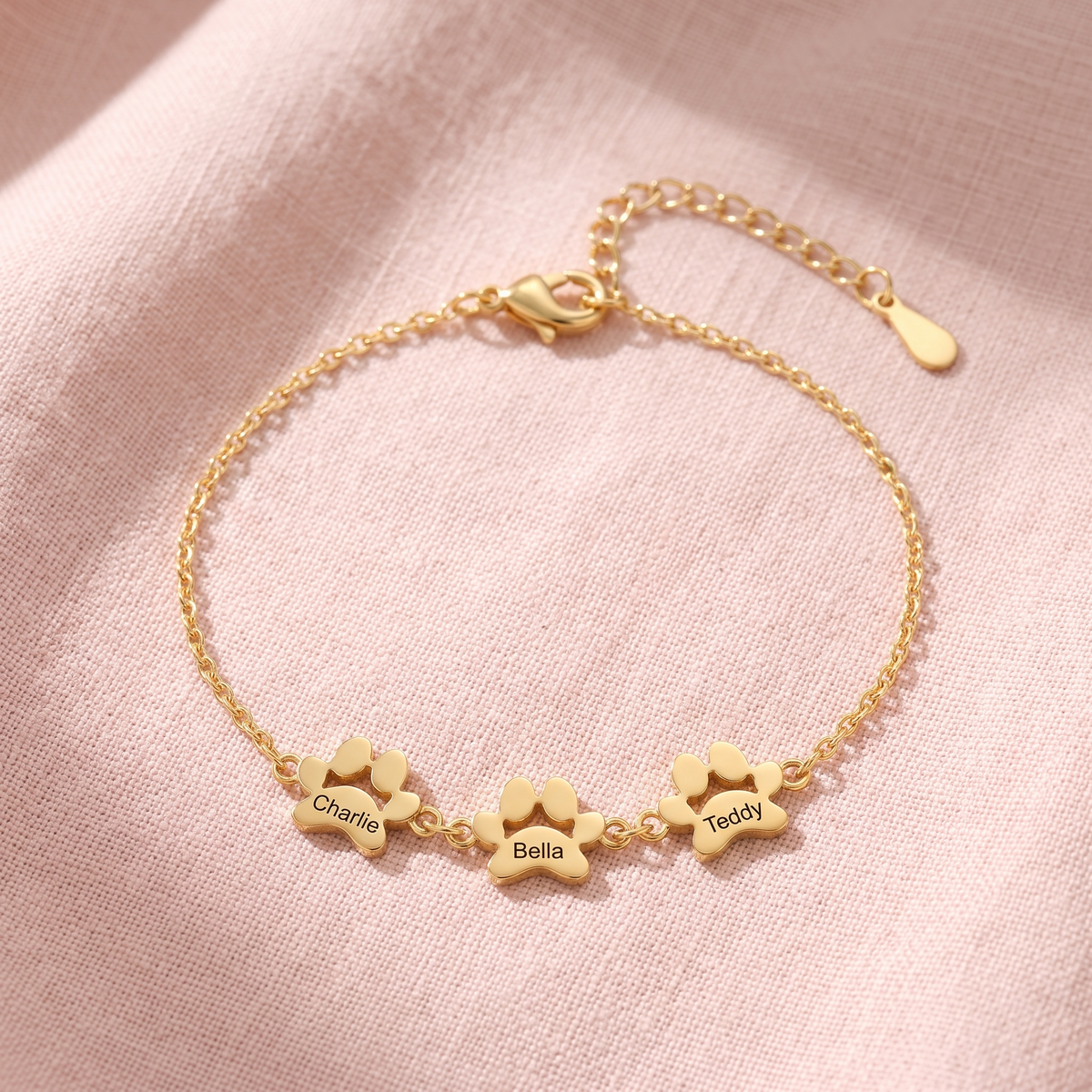 Gold paw print name bracelet with three engraved paws
